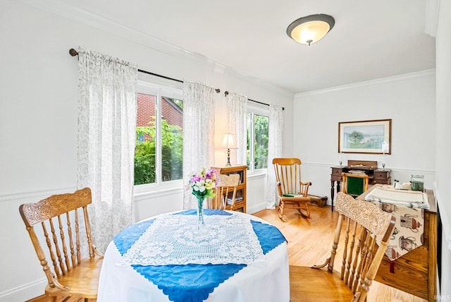 dining space featuring crown molding and light wood-style flooring