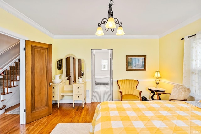 bedroom with a chandelier, ornamental molding, and wood finished floors