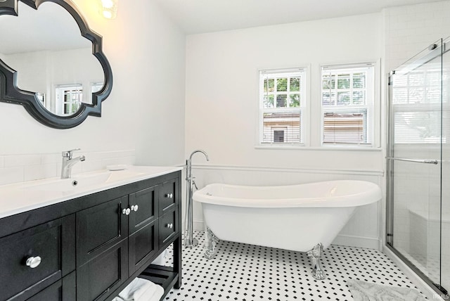 full bath with tile patterned floors, a shower stall, a freestanding bath, and vanity