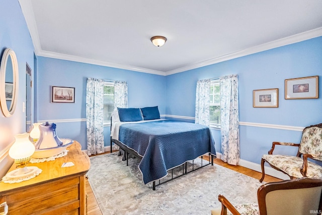 bedroom featuring ornamental molding, wood finished floors, and baseboards