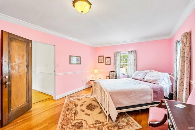 bedroom with baseboards, light wood-style flooring, and crown molding