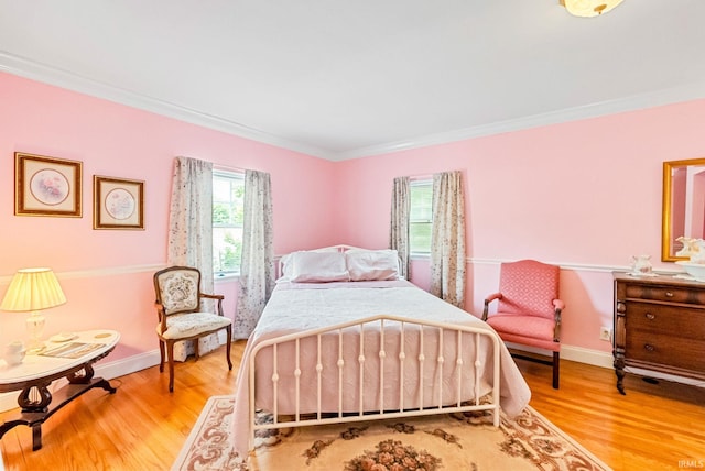 bedroom with ornamental molding, baseboards, and wood finished floors