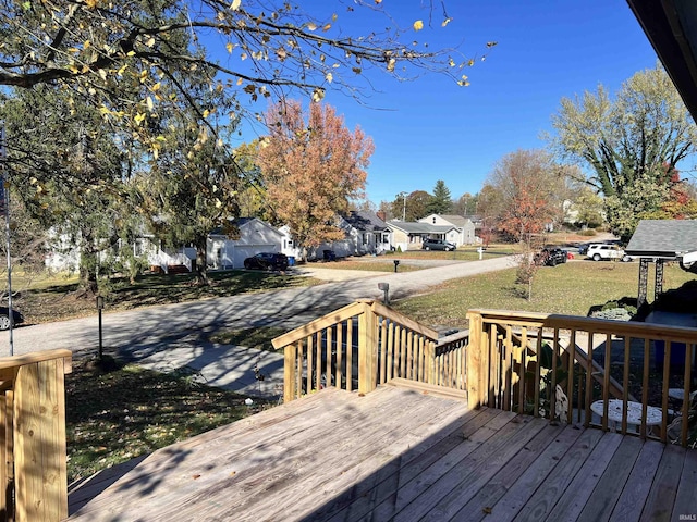 wooden terrace with a residential view and a lawn