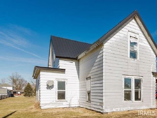 back of house with a yard and metal roof