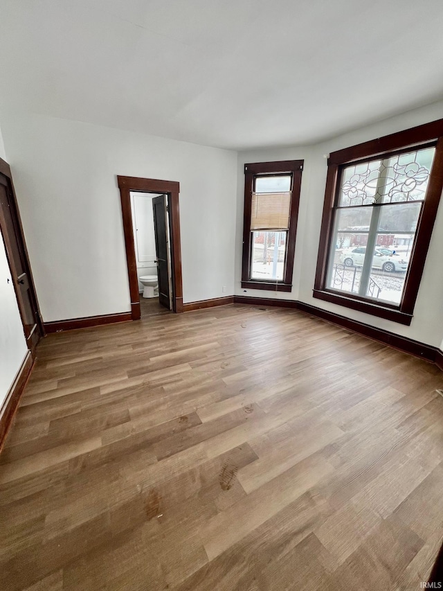 empty room with light wood-style flooring and baseboards