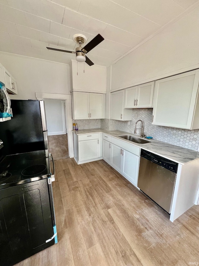 kitchen featuring stainless steel appliances, a sink, white cabinetry, light countertops, and backsplash