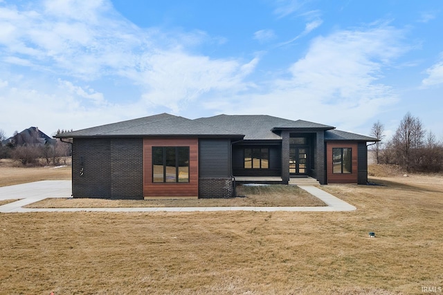 rear view of property featuring a yard and a shingled roof