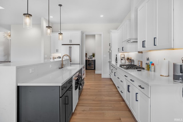 kitchen featuring pendant lighting, light countertops, stainless steel gas stovetop, and white cabinets