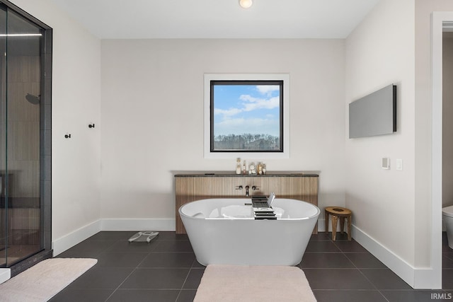 full bath featuring baseboards, toilet, a soaking tub, tile patterned floors, and a shower stall