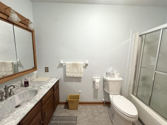 bathroom with baseboards, shower / bath combination with glass door, vanity, and toilet