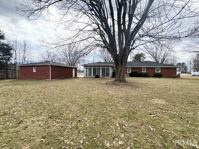 back of house featuring a yard and a sunroom