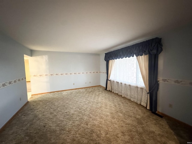 empty room featuring carpet floors and baseboards