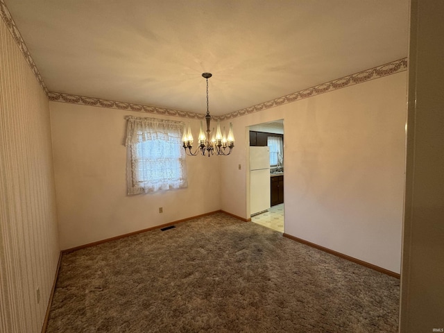 unfurnished dining area with carpet, visible vents, a notable chandelier, and baseboards