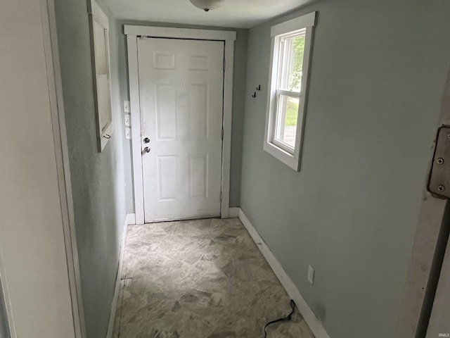 doorway featuring baseboards