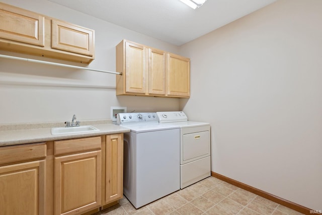 washroom with washer and clothes dryer, a sink, cabinet space, and baseboards