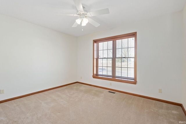 spare room with baseboards, visible vents, ceiling fan, and carpet flooring