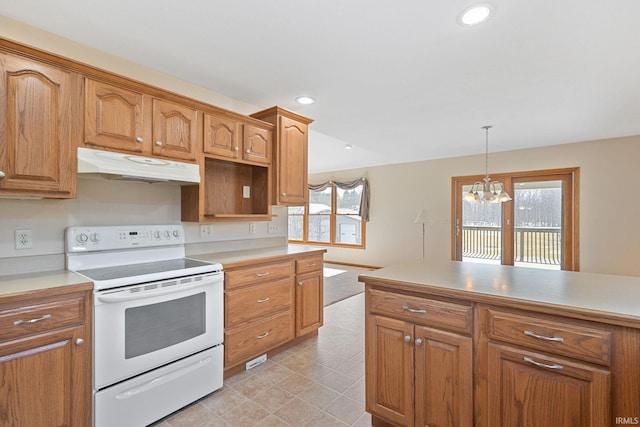 kitchen featuring under cabinet range hood, light countertops, hanging light fixtures, and electric range