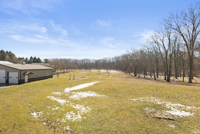 view of yard featuring a garage and a rural view