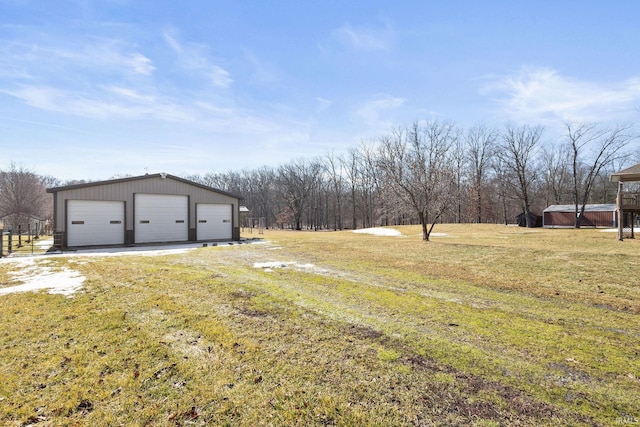 view of yard featuring a detached garage and an outbuilding