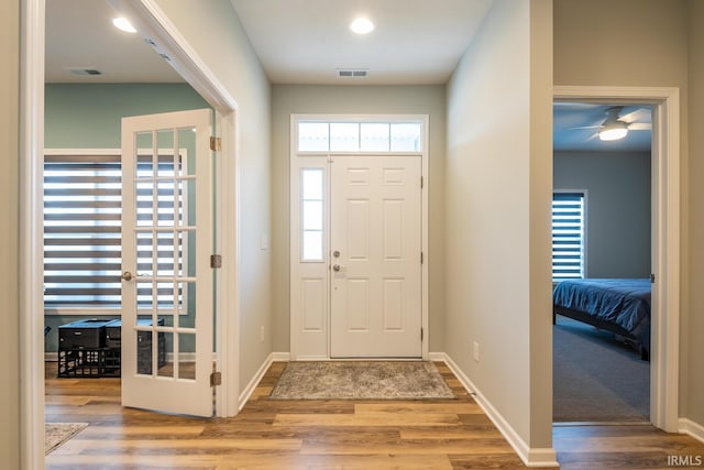 entrance foyer featuring baseboards, visible vents, and wood finished floors