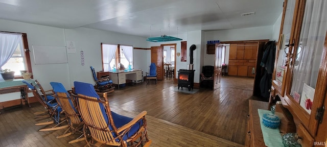 interior space featuring a wood stove, visible vents, and dark wood-type flooring