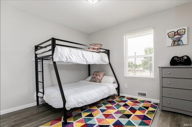 bedroom with visible vents, baseboards, and dark wood-type flooring