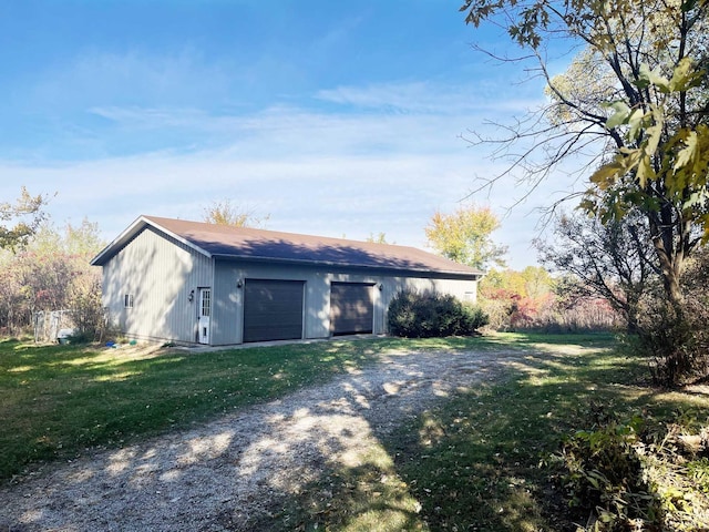 exterior space featuring driveway, a front yard, and an outdoor structure