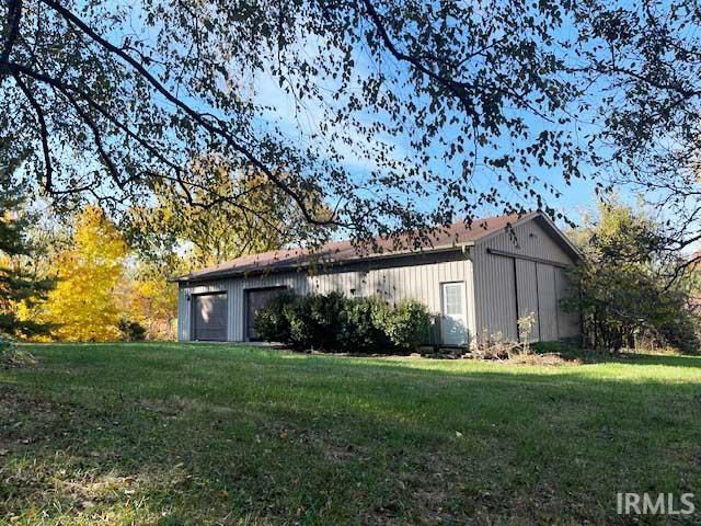 view of side of home featuring an outbuilding, a yard, and an outdoor structure