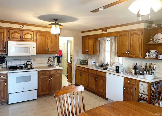 kitchen with brown cabinets, light floors, light countertops, white appliances, and wallpapered walls