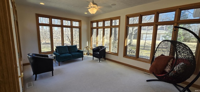 sunroom / solarium with a ceiling fan and visible vents