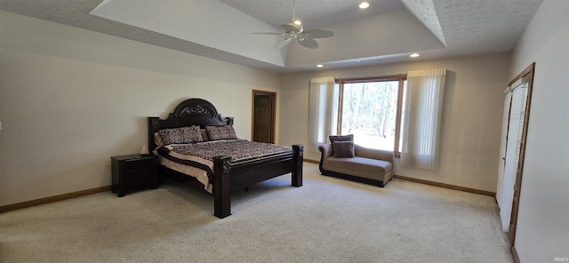 bedroom featuring recessed lighting, a raised ceiling, light colored carpet, and baseboards