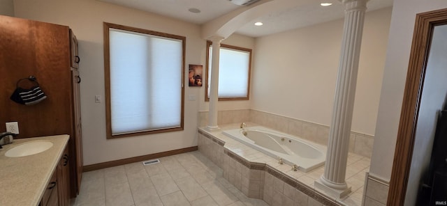 bathroom with decorative columns, visible vents, baseboards, a garden tub, and vanity