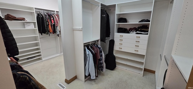 spacious closet featuring light colored carpet and visible vents