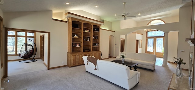 living area featuring high vaulted ceiling, baseboards, arched walkways, and light colored carpet