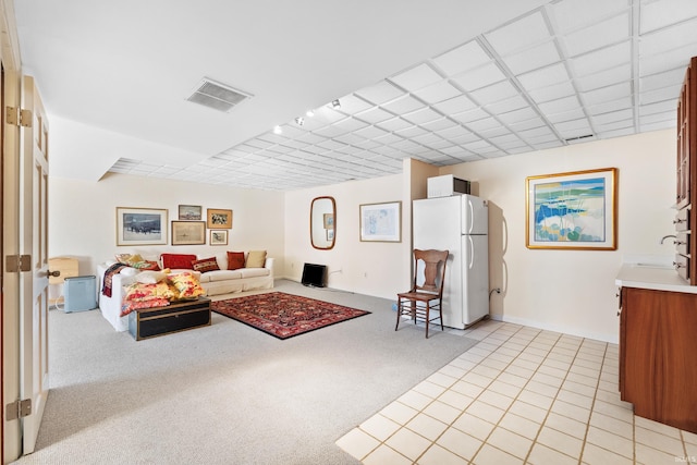 living area with light carpet, light tile patterned floors, and visible vents