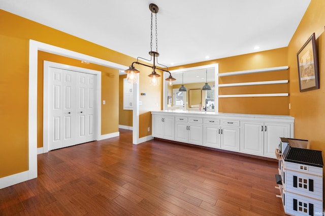 interior space with double vanity, baseboards, wood finished floors, and recessed lighting