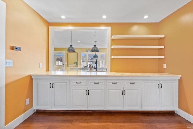 kitchen with white cabinetry, light countertops, and wood finished floors