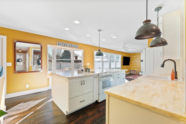 kitchen with white electric range, a kitchen island, a sink, visible vents, and hanging light fixtures