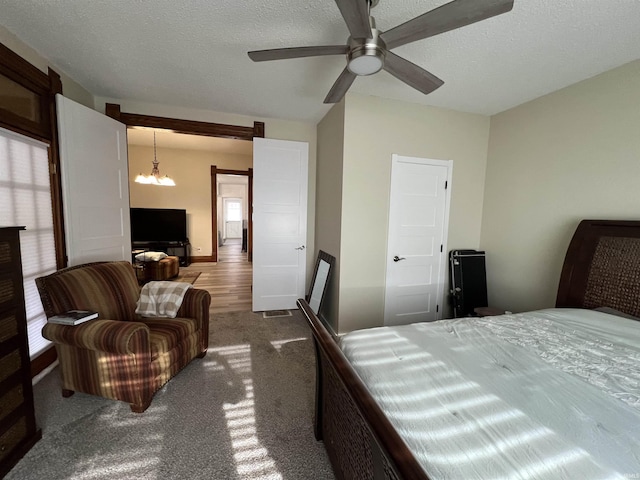 bedroom with multiple windows, ceiling fan, and a textured ceiling