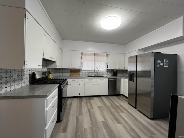 kitchen with stainless steel appliances, a sink, and white cabinetry