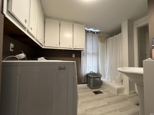 laundry area featuring visible vents, laundry area, light wood-type flooring, and washer / dryer