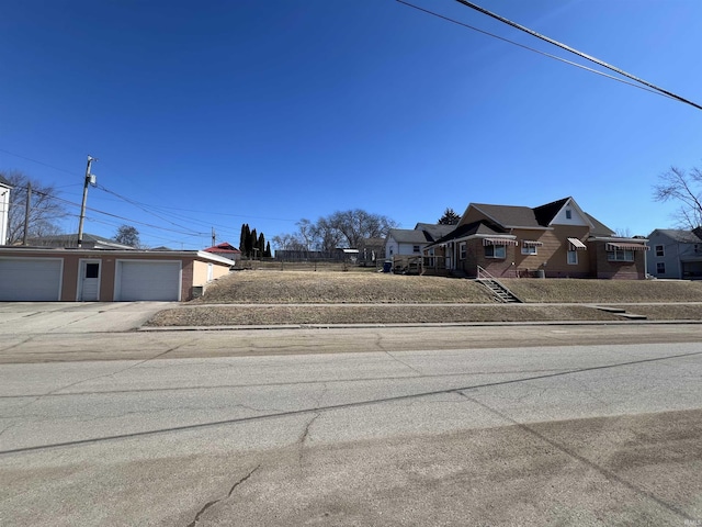 view of road with sidewalks, a residential view, and curbs