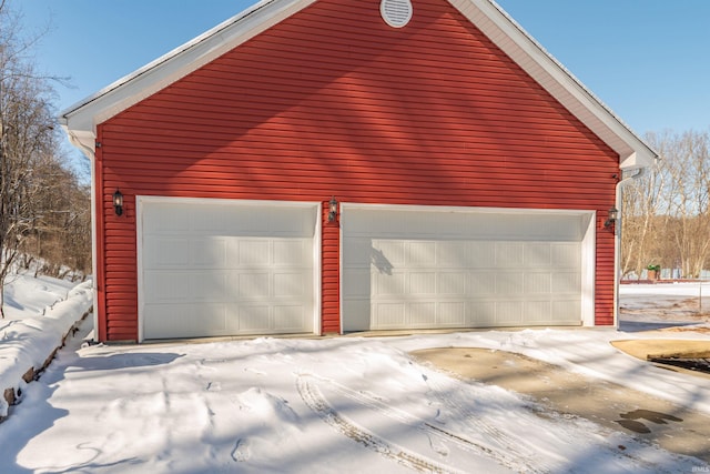 snow covered garage with a garage