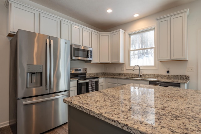 kitchen featuring white cabinets, light stone countertops, stainless steel appliances, and recessed lighting