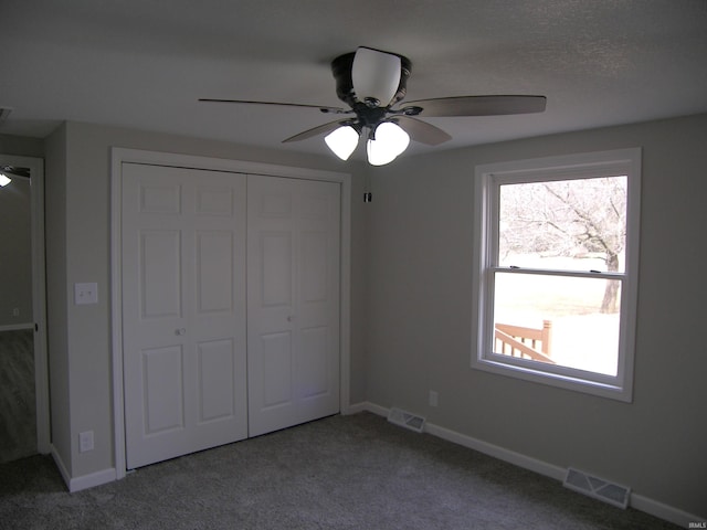 unfurnished bedroom featuring carpet, a closet, visible vents, ceiling fan, and baseboards