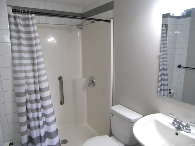 full bath with a sink, toilet, and a shower stall