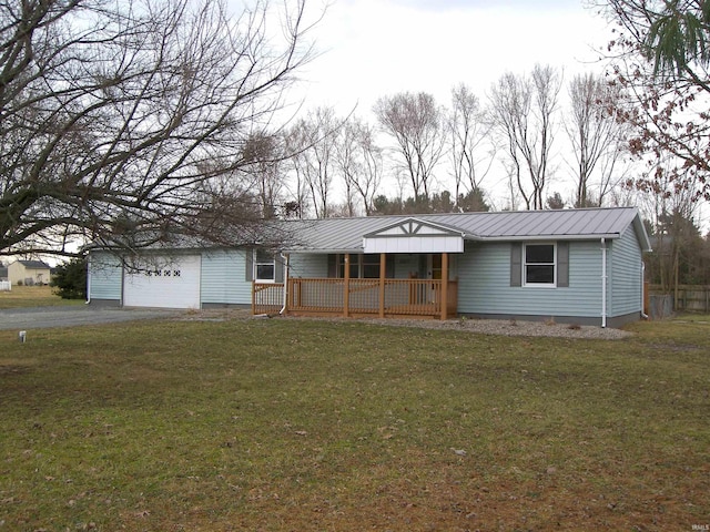 ranch-style house with a front yard, covered porch, metal roof, and driveway