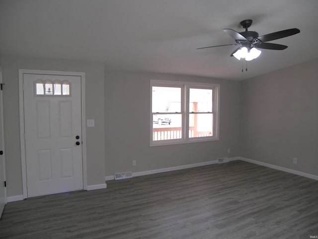 foyer with dark wood-style flooring, visible vents, and baseboards