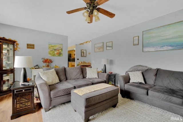 living area featuring light wood-style floors and a ceiling fan