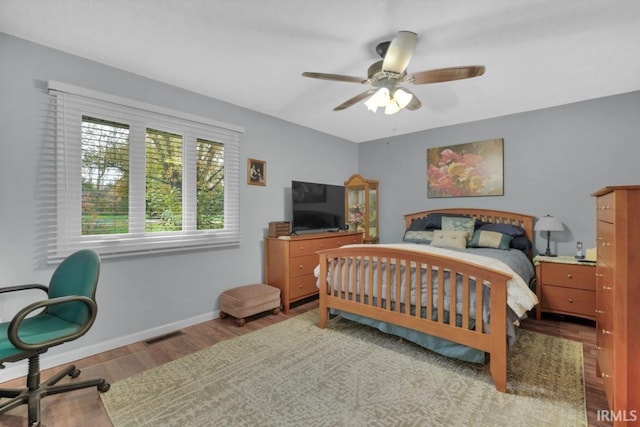 bedroom featuring light wood-style floors, a ceiling fan, visible vents, and baseboards